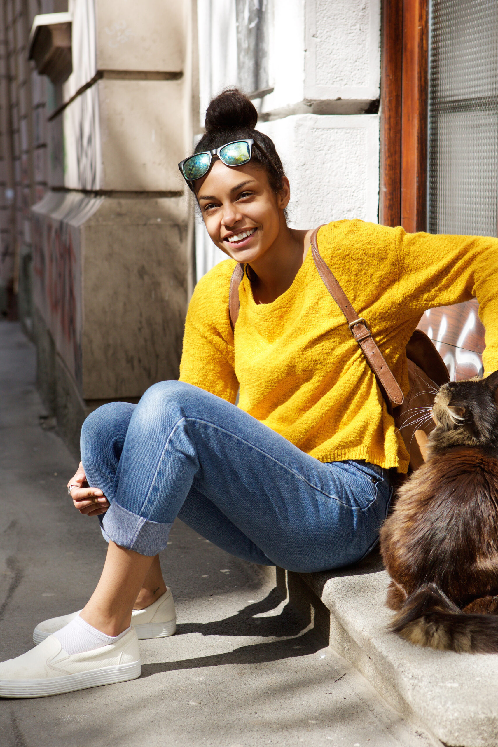 Home beautiful young woman sitting by a street with cat