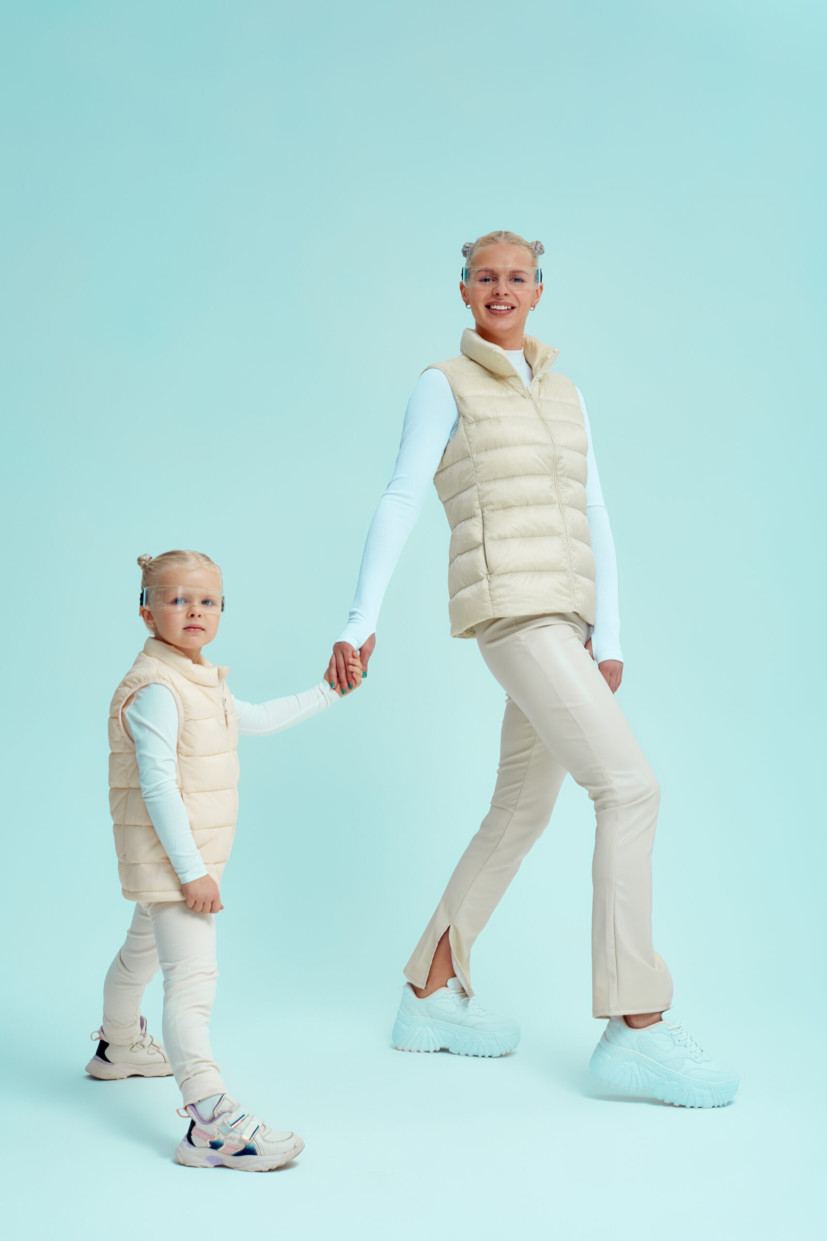 Home young girl kid child with mother wearing smart glasses and explore alternative reality. cyber space and virtual gaming. discover future technology on blue background